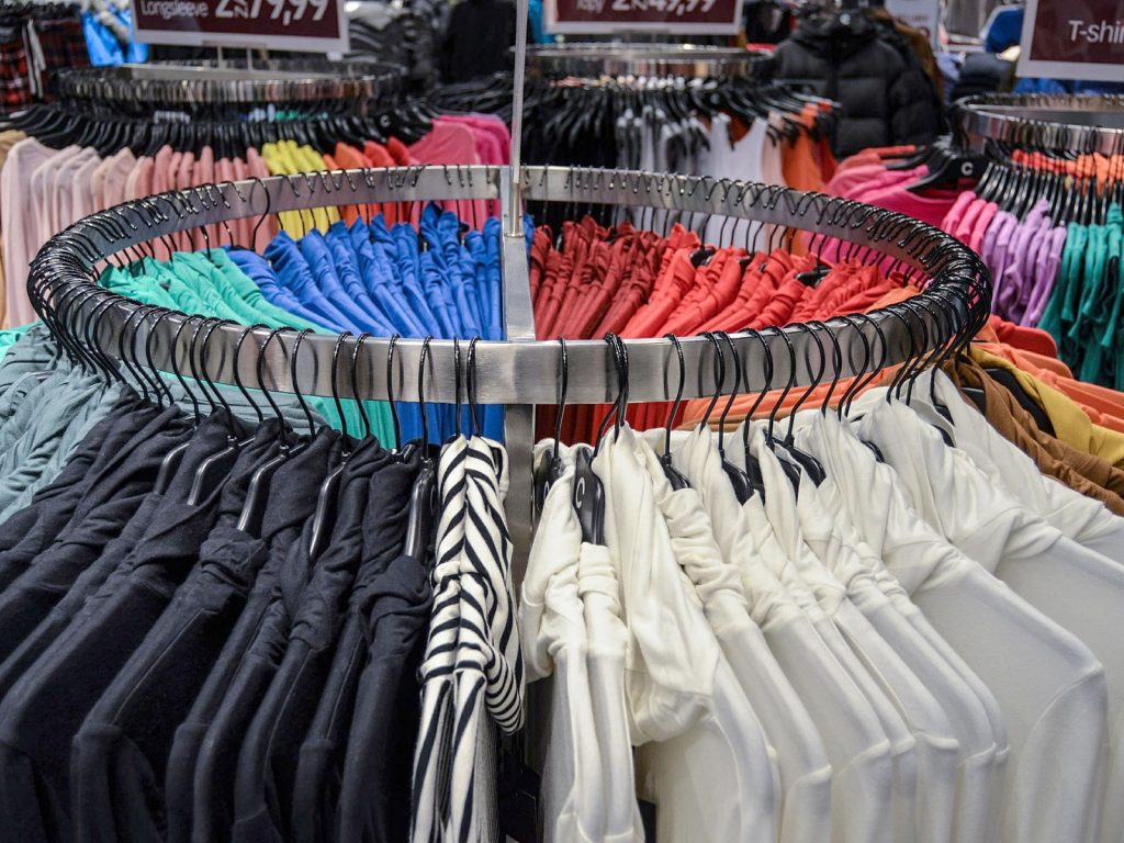Fast Fashion: vollgepackte Kleiderständer im Shop (Jarmoluk via Pixabay