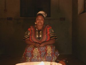 Still vom Dokumentarfilm "Stimmen vom Feuer": Grizelda aus Südafrika am Feuer. (Foto: Carla Muresan, FILMALLEE))