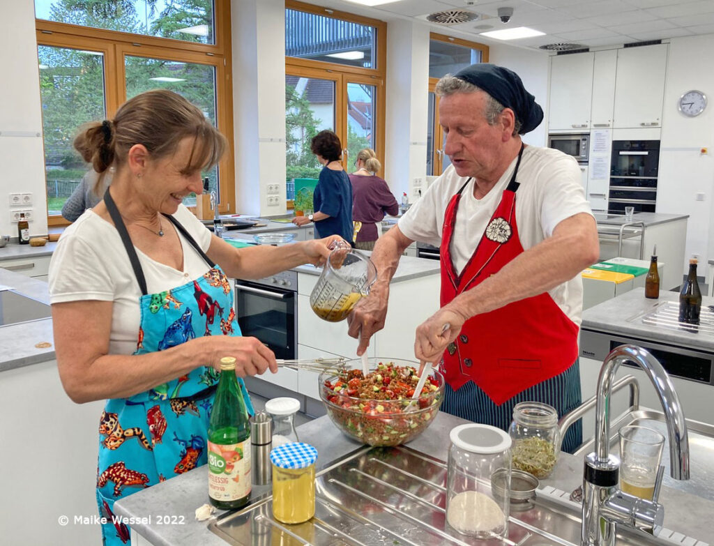 Menschen in einer Lehrküche beim Gemeinsamen Kochen & Genießen, veranstaltet von Weilheimer AGENDA und SlowFood Pfaffenwinkel. (Foto: Maike Wessel)